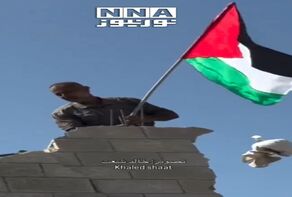 דגל פלסטין מתנוסס מעל הריסות עזה.