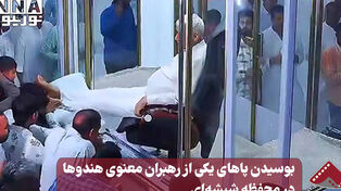 نورنما | بوسیدن پاهای یکی از رهبران معنوی هندوها در محفظه شیشه ای